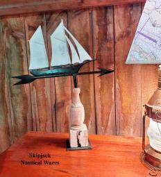 Old painted metal schooner weathervane on directional arrow. Now displayed on a turned wood pedestal